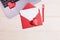 Blank paper in red envelope, a pen,a laptop, hearts on a white background.