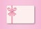 Blank pastel gift card with red ribbon bow on pink background, Gift voucher or greeting card concept.