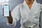 . Blank phone screen and copyspace with a karate student holding the mobile display indoors. Sport person showing a copy