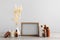 Blank photo frame, different bottles and decor elements on wooden table