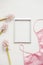 Blank photo frame, silk lingerie and pink flowers on white background. Styled feminine flat lay, top view, copy space