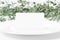 Blank place card on a white plate with greenery background.