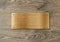 Blank polished golden name plate on wooden background