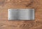 Blank polished silver plate on wooden background