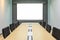 Blank projection screen in meeting room with conference table