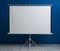 Blank projection screen near blue wall indoors