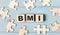 Blank puzzles and wooden cubes with the text BMI Body Mass Index lie on a blue background