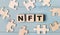 Blank puzzles and wooden cubes with the text NFT Non-Fungible Token lie on a light blue background