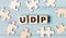 Blank puzzles and wooden cubes with the text UDP User Datagram Protocol lie on a light blue background