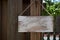 Blank rustic sign hanging from wooden fence