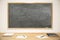 Blank school blackboard with books, exercise books and pens