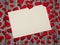 A blank sheet of paper, a scattering of red hearts on a wooden background.