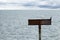 Blank Sign board iron on pole in the sea with reflection light in rippled effect textured water for design backgrounds and