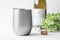 Blank silver wine tumbler mockup with greenery, wine bottle and bottle opener.