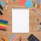 Blank Sketch book and school colorful tools on wood background