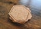 Blank stack coaster mockup with cork texture on wooden surface. Hexagonal drink pad pile template