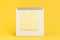 Blank sticky note with copy space to put text on desktop calendar on yellow background using as reminder, important message or mem