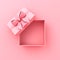 Blank sweet pink pastel color present box or top view of open gift box with pink ribbon and bow on pink background