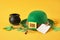 blank tag, glasses, coins, leprechaun hat and clover leaves on yellow background, st. patrick's day concept, save