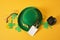 blank tag, glasses, coins, leprechaun hat and clover leaves on yellow background, st. patrick's day concept, save