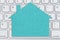 Blank teal house sign on gray keyboard