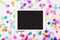 Blank touchscreen display with colorful confetti on white background. Flat lay of touchpad computer on white background