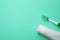 Blank tube of toothpaste and brush on color background