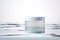 Blank, unbranded cosmetic cream jar standing in water. Skin care product presentation. Skincare, beauty. Jar with copy