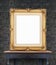 Blank vintage golden photo frame lean at black brick wall on woo