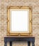 Blank vintage golden photo frame lean at pale orange brick wall