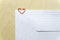 Blank white envelopes on wooden desk with heart shaped paper clip
