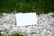 Blank white folded paper on the gravels and grasses