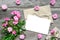 Blank white greeting card with pink rose flowers bouquet and envelope with flower buds and gift box