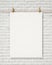 Blank white hanging poster with clothespin and rope on brick wall, background