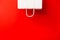 Blank white paper bag isolated on red background. Black friday, sale, discount, recycling, shopping and ecology concept.
