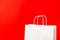 Blank white paper bag isolated on red background. Black friday, sale, discount, recycling, shopping and ecology concept.