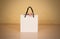 Blank white paper gift bag with a bow mock up standing on a wood
