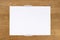 Blank white paper page note stick on wooden background with gray sticky tape