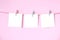 Blank white papers notepad hanging on pink background