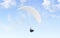 Blank white paraglider with person in harness mockup, sky background