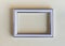 Blank white picture frame on a plain beige background.