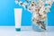 Blank white plastic tube organic natural skincare products and flower. Packaging of lotion, cream or serum cosmetic