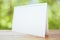 Blank white postcard on wooden table outdoor