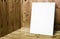 Blank white poster leaning at wooden wall in plank wood room,Mock up for adding your content.