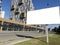 Blank white road billboard in city in summer sunny day. Street advertising poster, mock up, Glued paper mockup