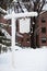 A blank white rustic sign covered in snow