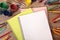 Blank white school writing book, school desk, pencils, art supplies, copy space