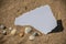 Blank white sheet of paper on white sand with seashells and stones. Message by the sea, romance, valentine's