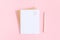 Blank white sheet on spiral golden notepad with paper clip heart and pencil on pink pastel background. Mock up for your text and
