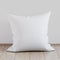 Blank white soft square pillow on a wooden floor near the wall, 3D render